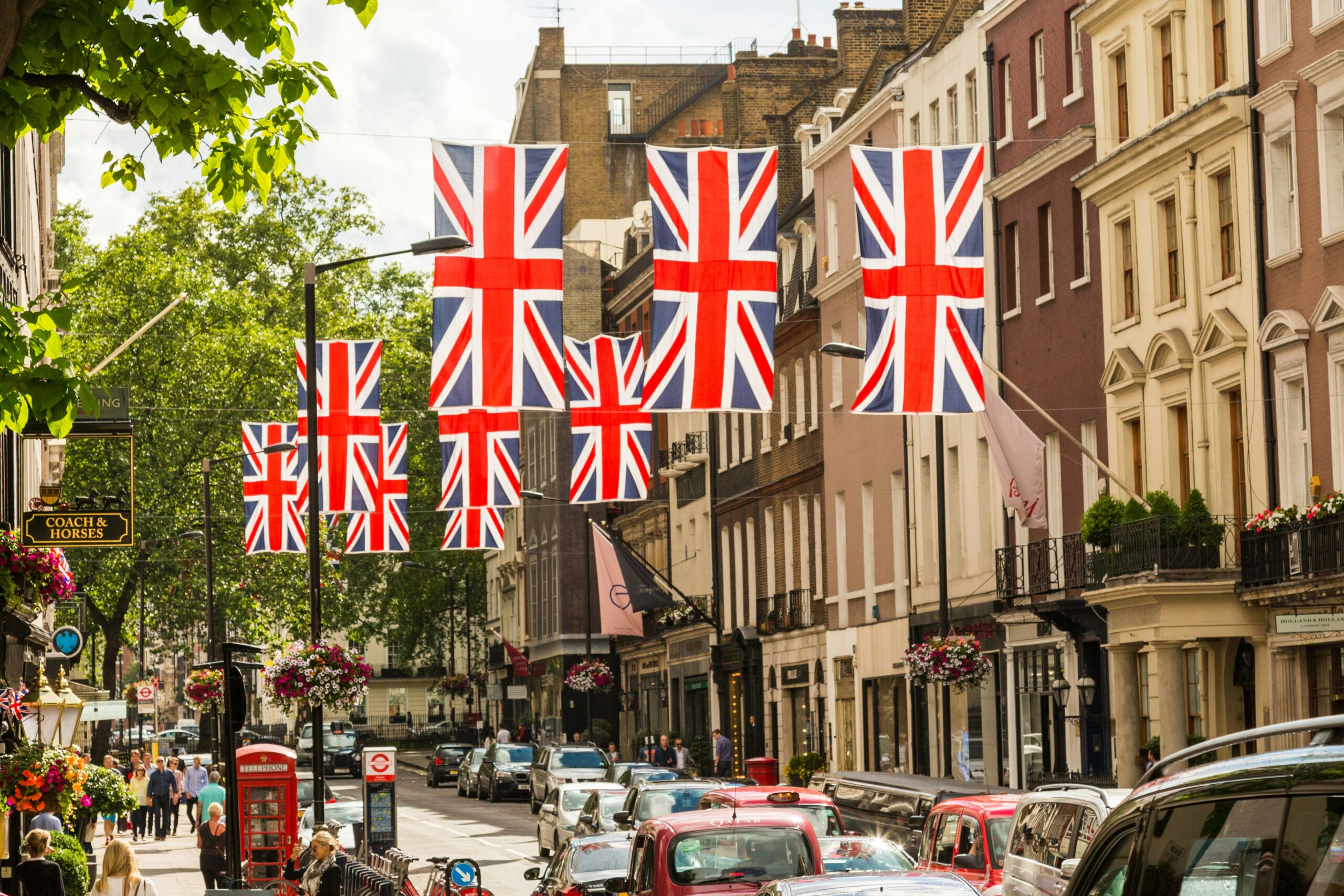 Traditional British street with union jack flags hanging over the road.