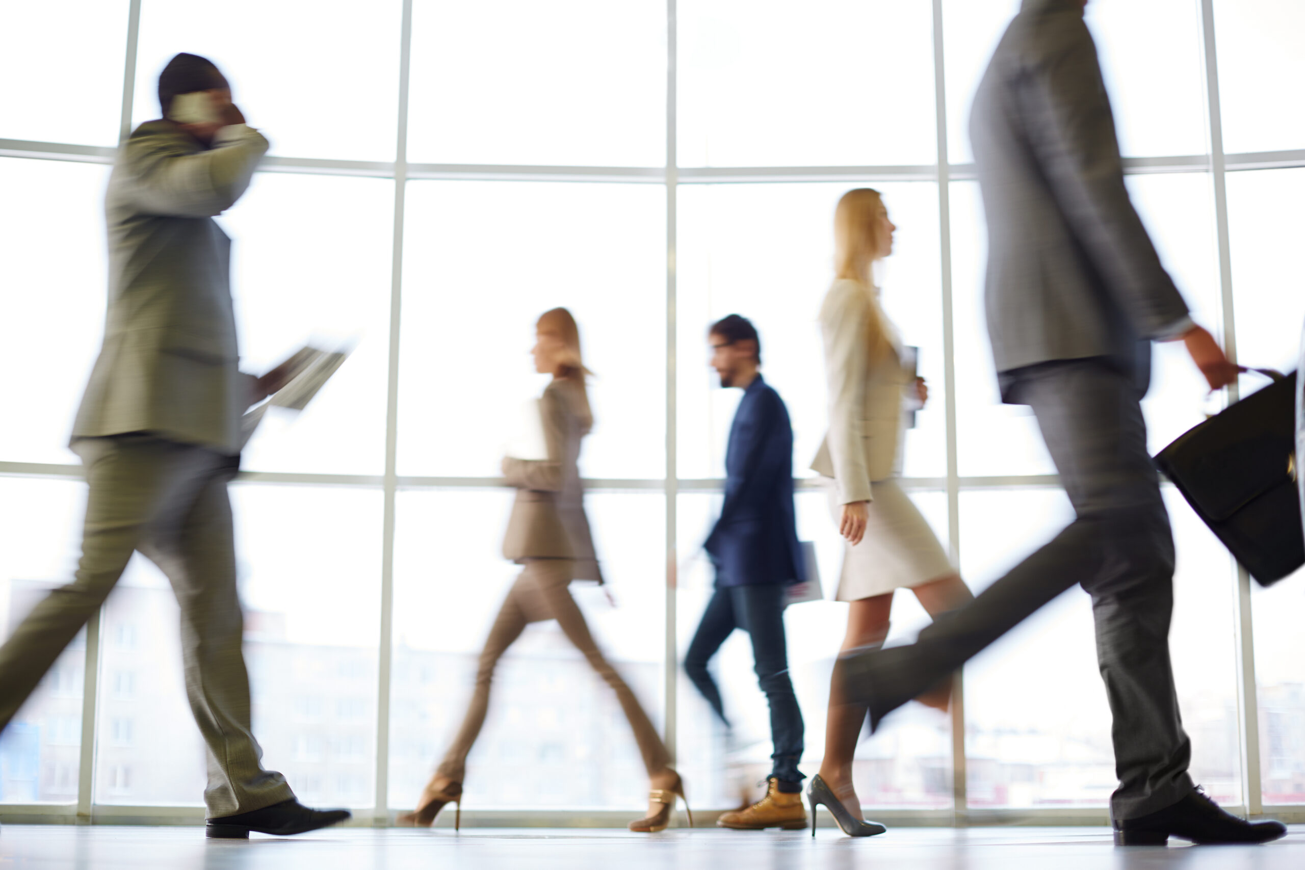 White collar workers going down office corridor at the end of working day.