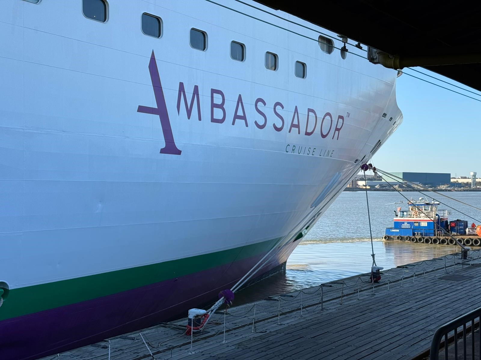 View of the hull of a cruise ship and the dock it is docked at.