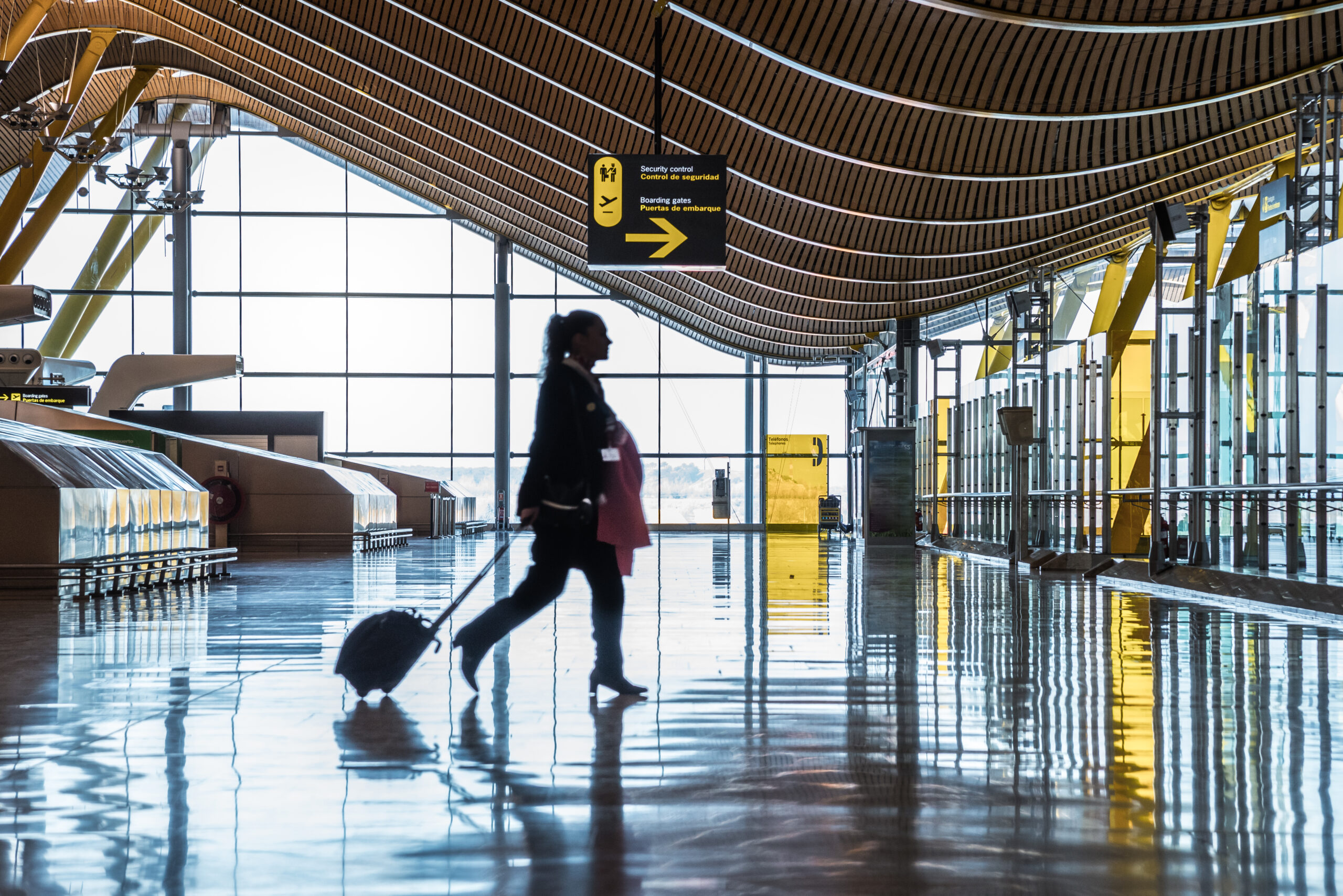 airport terminal with people moving silhouettes and sun-ray.